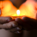 Hands holding candle--hope illuminates