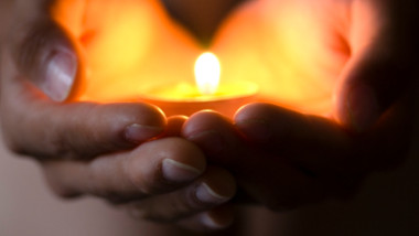 Hands holding candle--hope illuminates