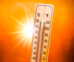 Thermometer over 100 degrees with hot sun in the background