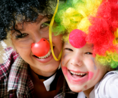 Laughing kids wearing clown noses and wigs