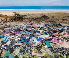 Fast fashion illustrated by sandals washed up on shore